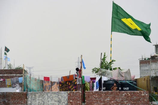 A child hoists the national flag of Argentina on the outskirts of Dhaka during the 2018 World Cup